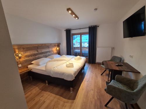 a bedroom with a bed and a table and a desk at Hotel Pension Annerlhof in Maria Alm am Steinernen Meer