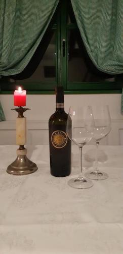 a bottle of wine with two glasses and a candle at Bakina iža in Duga Resa