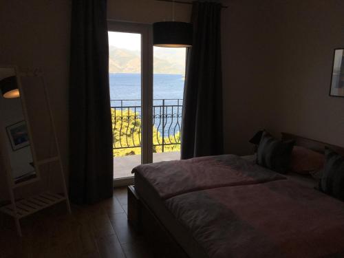 a bedroom with a bed and a view of the ocean at THE VIEW **** in Račišće