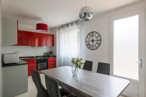 una cocina con una mesa con un jarrón de flores. en logement 004 a 300m de la gare Mantes la jolie, en Mantes-la-Jolie