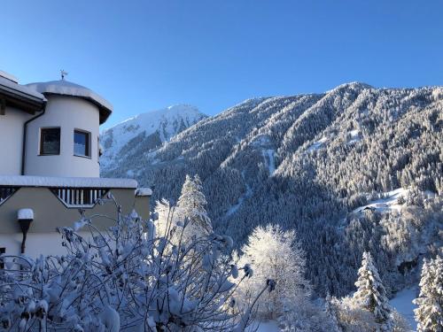 een gebouw met uitzicht op een met sneeuw bedekte berg bij Gschlössle Ferienwohnungen in Jerzens