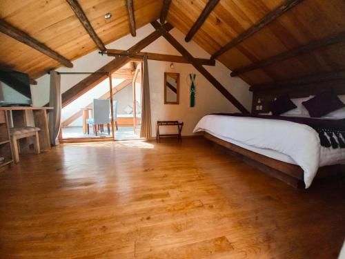 a bedroom with a large bed and a wooden floor at Hotel Junvay in San Cristóbal de Las Casas