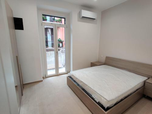 Bilocale incantevole a Barletta - Puglia في بارليتا: غرفة بيضاء مع سرير ونافذة