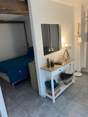 a room with a bed and a table with a mirror at Joli appartement quartier historique in Moulins