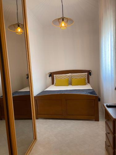 a bedroom with a bed with yellow pillows and a mirror at Casas da Praia in Nazaré