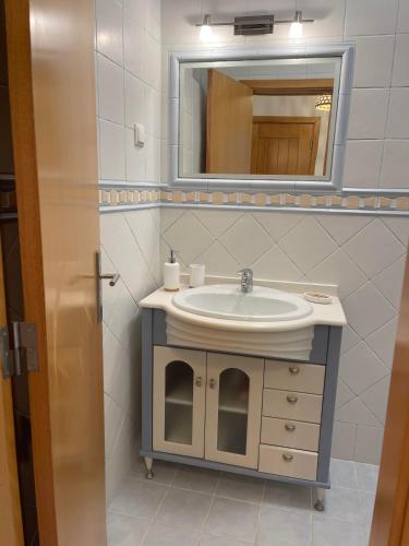 a bathroom with a sink and a mirror at Casas da Praia in Nazaré