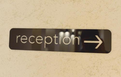 a sign with the word reception on a wall at Corso Rooms City Centre in Novi Sad