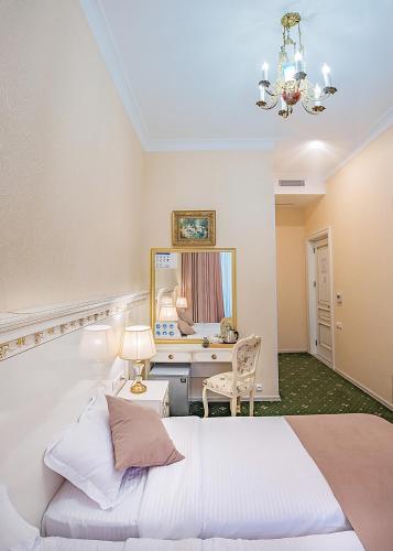 a bedroom with a white bed and a desk at Vintage Hotel in Tbilisi City