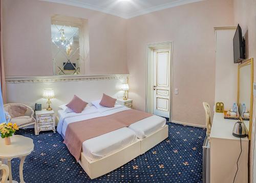 a bedroom with a bed and a table and a television at Vintage Hotel in Tbilisi City