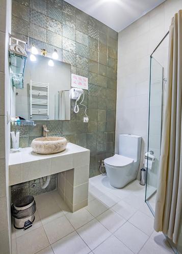 a bathroom with a sink and a toilet at Vintage Hotel in Tbilisi City