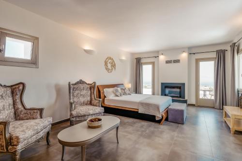 ein Schlafzimmer mit einem Bett, einem Sofa und einem Tisch in der Unterkunft Kaminos Private Villa in Vóthon