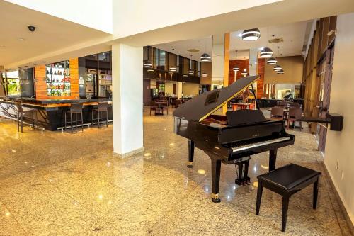 a piano sitting on top of a wooden table in a restaurant at SJ Premium Hotels By Atlantica in Goiânia