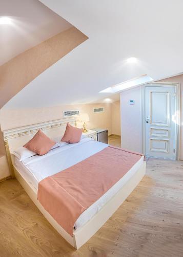 a bedroom with a large white bed with pink pillows at Vintage Hotel in Tbilisi City