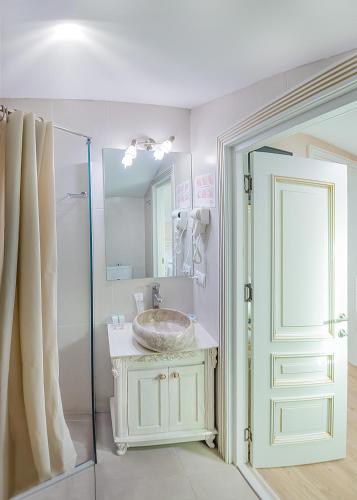 a bathroom with a sink and a shower and a mirror at Vintage Hotel in Tbilisi City