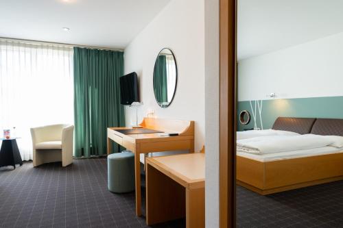 a hotel room with a bed and a desk at Hotel Schatzmann in Triesen