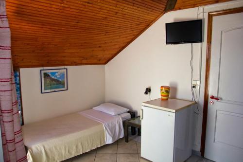 a bedroom with a bed and a tv in a room at Hotel Miramare in Pylos