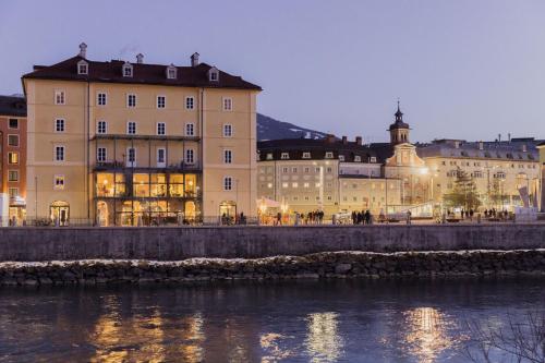 a group of buildings next to a river at Marktbar Studios - Boutique Aparthotel in Innsbruck