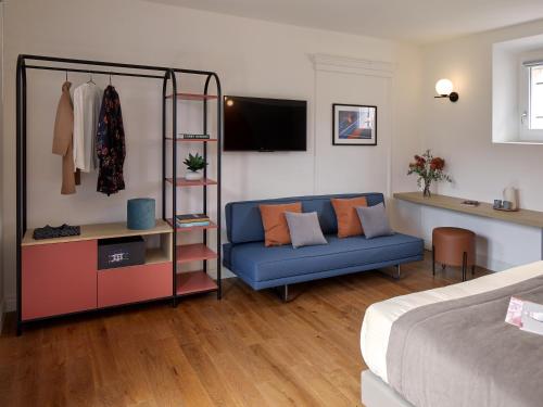 ein Wohnzimmer mit einem blauen Sofa und ein Schlafzimmer in der Unterkunft Ca’ Prandini in Maranello