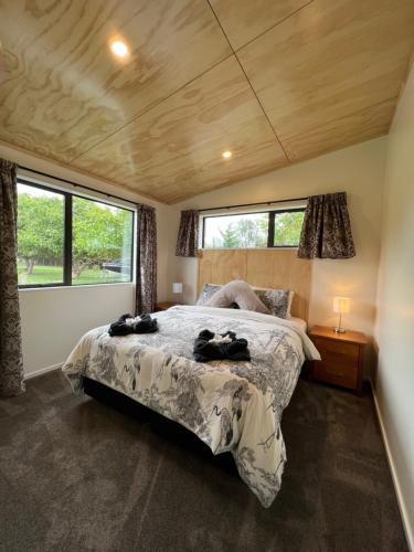 a bedroom with a large bed in a room with windows at Country Retreats on Ranzau 9 in Hope