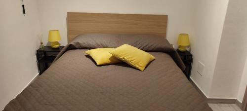 Una cama con dos almohadas amarillas encima. en Casa Jose', en Palermo