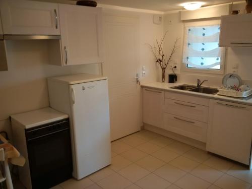 een keuken met een witte koelkast en een wastafel bij Appart 53 m2 en Rdc maison, jardin, à 50 m plage in La Turballe