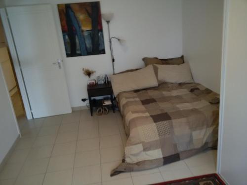 une chambre avec un lit et un sol carrelé dans l'établissement Appart 53 m2 en Rdc maison, jardin, à 50 m plage, à La Turballe