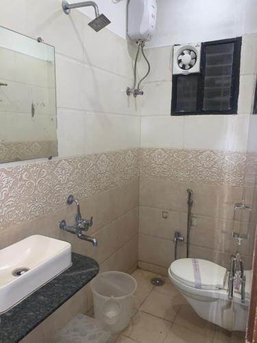 a bathroom with a sink and a toilet and a mirror at JK Rooms 126 Parashar Legacy - Opp Railway Station in Nagpur