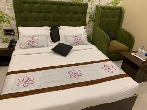 a bedroom with a bed with pink flowers on it at JK Rooms 126 Parashar Legacy - Opp Railway Station in Nagpur