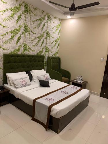a bedroom with a bed with a green headboard at JK Rooms 126 Parashar Legacy - Opp Railway Station in Nagpur