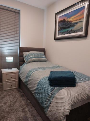 a bedroom with a bed with a blue bag on it at Portstewart Atlantic Cove Hatheran Gardens in Portstewart