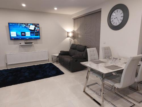 a living room with a couch and a table and a tv at Portstewart Atlantic Cove Hatheran Gardens in Portstewart