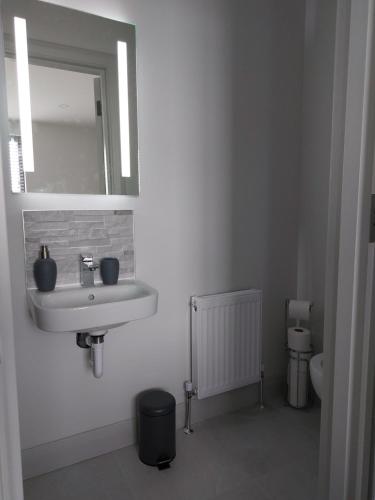 a bathroom with a sink and a mirror at Portstewart Atlantic Cove Hatheran Gardens in Portstewart