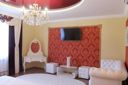 1 dormitorio con sofá y TV en la pared en Sobkoff, en Khmelʼnytsʼkyy