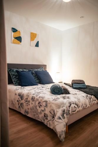 une chambre avec un grand lit avec des oreillers bleus dans l'établissement Vernon : La Marinière, à Vernon