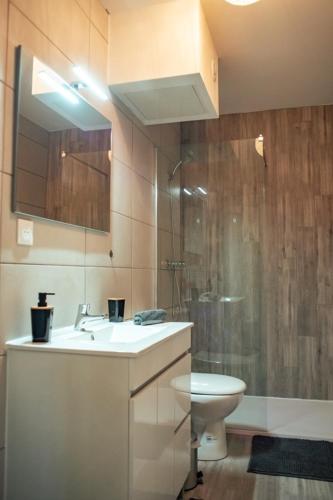une salle de bain avec un lavabo, des toilettes et une douche dans l'établissement Vernon : La Marinière, à Vernon
