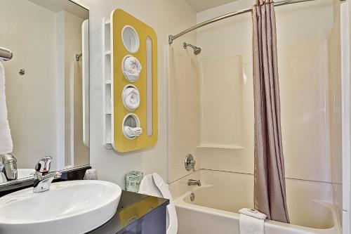 uma casa de banho branca com um lavatório e um chuveiro em Motel 6-Villa Park, IL - Chicago West em Villa Park