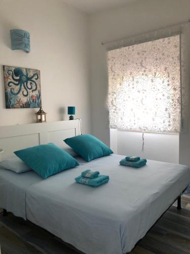 un letto bianco con due asciugamani sopra di Maison Turquoise a Cala Gonone