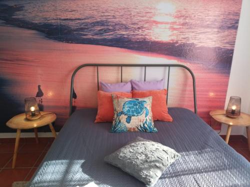a bedroom with a bed with a painting on the wall at Silva's House in Vila Nova de Milfontes