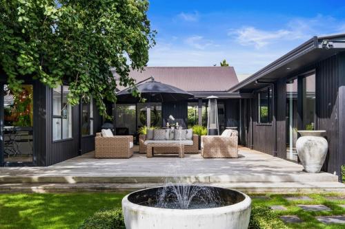 a courtyard with a fountain in front of a house at Black Luxury Lodge in Blenheim