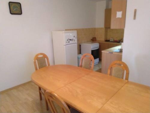 HannaH - Relax dom pod orechom - 4i Apartmán في Trávnica: مطبخ مع طاولة وكراسي وثلاجة بيضاء
