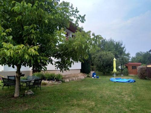un patio con un árbol y una bandera amarilla en HannaH - Relax dom pod orechom - 4i Apartmán, en Trávnica