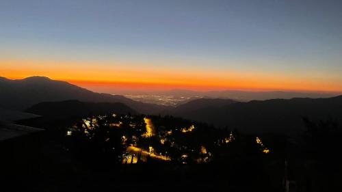 a view of a city from a mountain at sunset at Casa en Farellones in Santiago