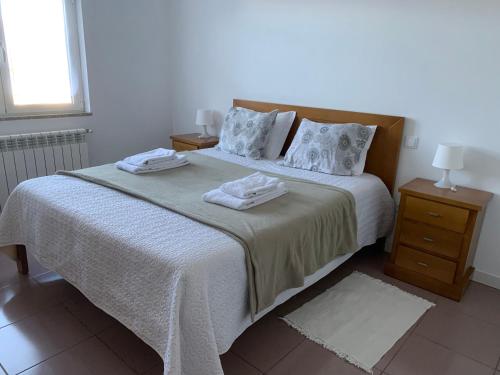 1 dormitorio con 1 cama con 2 toallas en Casa de Casarelhos - Estúdio - T1 - T2 - Gerês, en Gerês