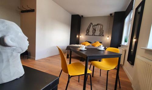 ein Esszimmer mit einem Tisch und gelben Stühlen in der Unterkunft GRYF Apartamenty Holiday Family in Stettin