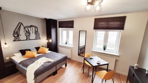 sypialnia z łóżkiem, stołem i dwoma oknami w obiekcie GRYF Apartamenty Holiday Family w Szczecinie