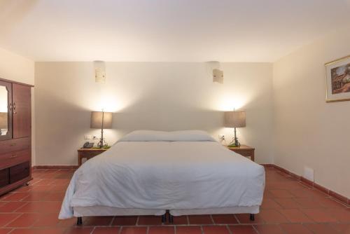 um quarto com uma cama grande e 2 candeeiros em Hotel San Gil Campestre em San Gil