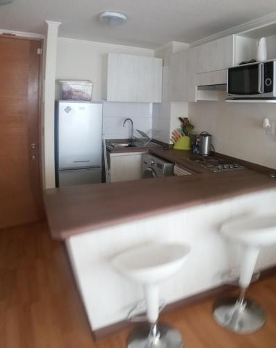 a kitchen with a counter and a refrigerator at Departamento La Serena in La Serena