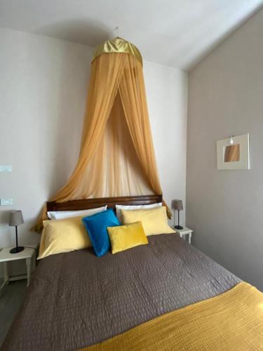 a bedroom with a bed with yellow and blue pillows at Bed & Breakfast Cascina Beatrice in Rodello