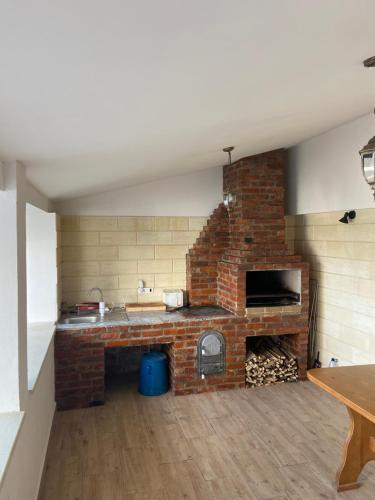 a kitchen with a brick fireplace in a room at Casa Andreea in Sînmartin
