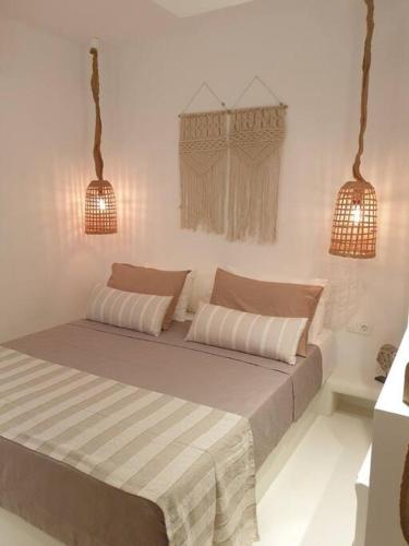 a bed in a white room with two lights at Amalthea Guest House in Kos Town